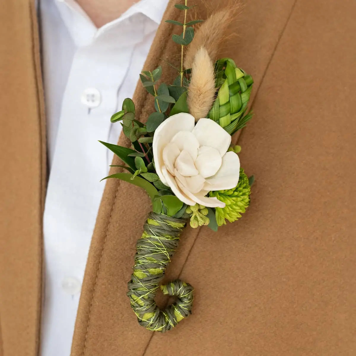 BoutStix magnetic boutonniere on a brown coat with a white shirt
